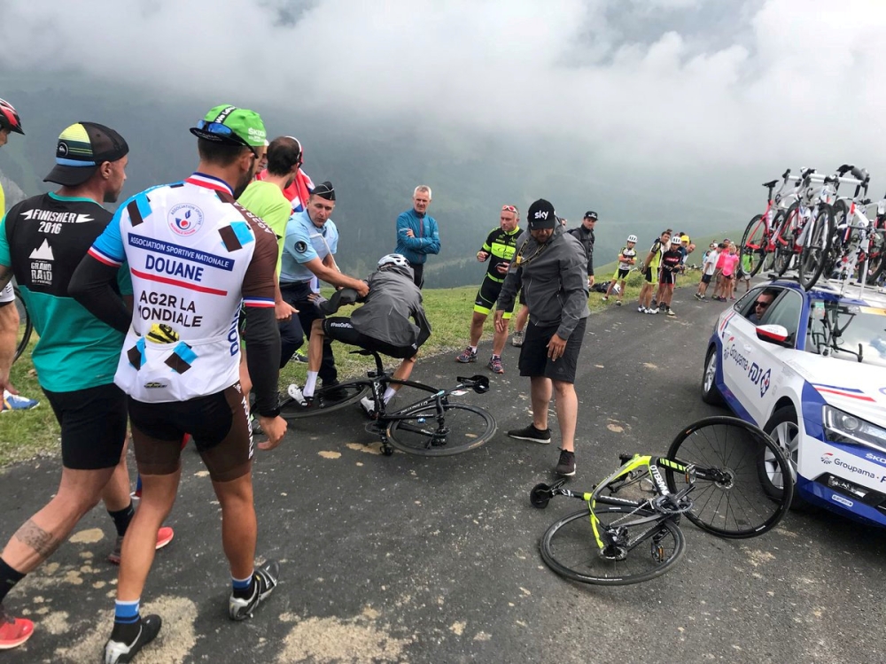 Chris Froome of Britain who was mistaken for a fan is pulled off his bike by a police officer, July 25, 2018. (Albert Secall via Reuters) 