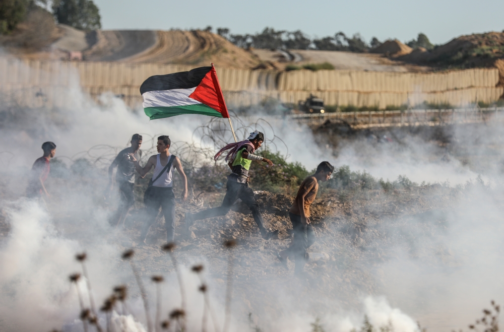 Demonstrators are affected by tear gas smoke launched by Israeli security forces as they intervene in a demonstration within the 