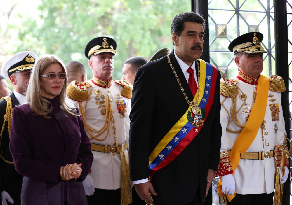 Venezuela's President Nicolas Maduro stands next to his wife Cilia Flores and Defense Minister Vladimir Padrino Lopez, as he arrives for a military parade to celebrate the 208th anniversary of Venezuela's declaration of independence in Caracas, Venezuela 