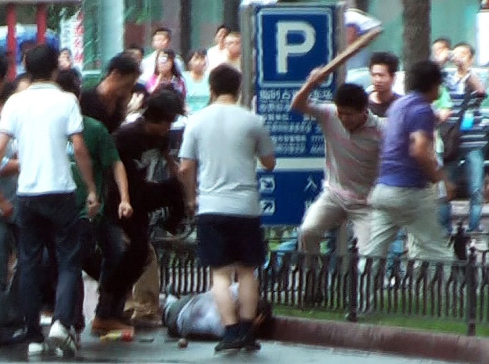 This file image taken on July 8, 2009 shows an AFP TV grab showing a mob of Han Chinese attacking a lone Muslim Uighur man along a street in Urumqi, China's farwest Xinjiang region. AFP TV / Sam Beattie