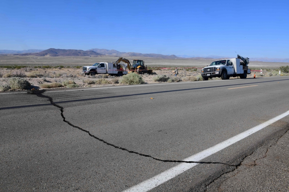 A crack on Highway 178 is seen as construction workers fix a broken water line south of Trona, after a 6.4-magnitude earthquake hit in Ridgecrest, California, on July 4, 2019. AFP / FREDERIC J. BROWN