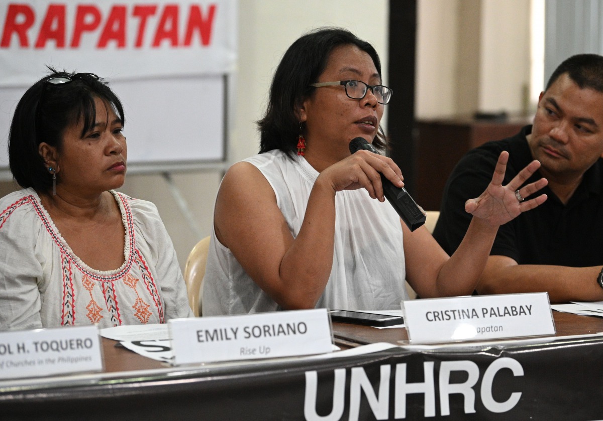 Tinay Palabay (2nd R) of Karapatan, an alliance for the advncement of people's rights, speaks during a press confence in Manila on July 13, 2019, a day after the United Nations Human Rights Council approved a resolution mandating a comprehensive internati