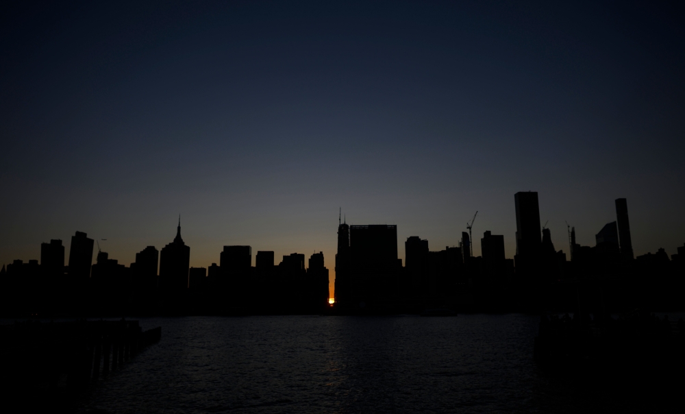 The sun sets behind 42nd Street in Manhattan during a power outage in New York City on July 13, 2019. AFP / Johannes Eisele 