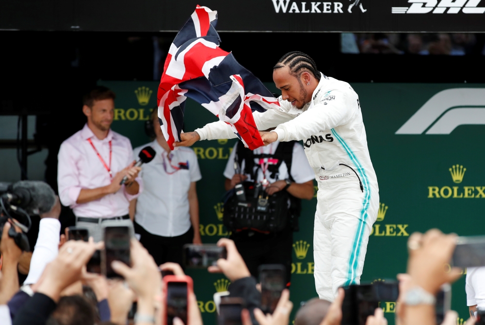 Mercedes' Lewis Hamilton waves a British flag as he celebrates winning the race (REUTERS/Matthew Childs)
