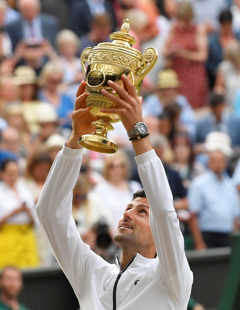 Novak Djokovic poses with the trophy as he celebrates winning the final against Switzerland's Roger Federer. Reuters/Toby Melville