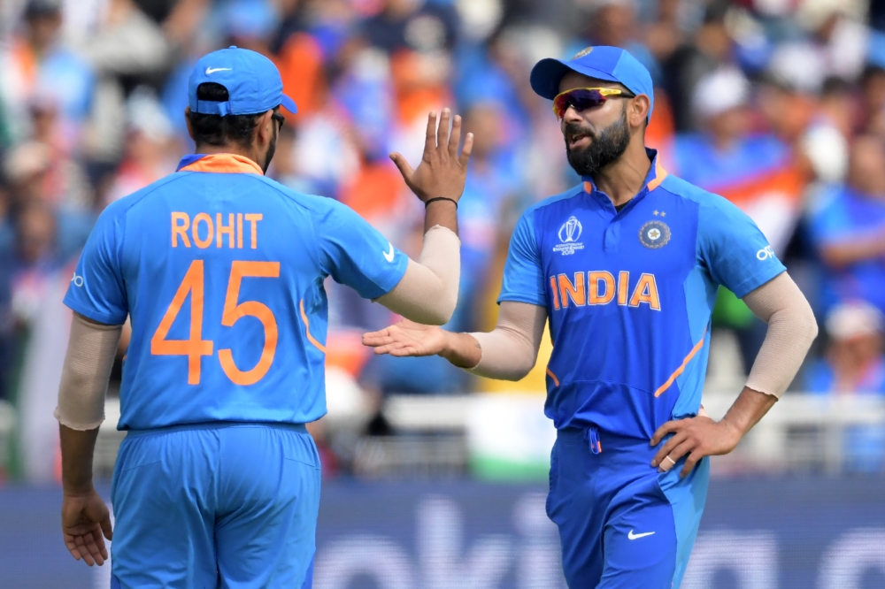 India's captain Virat Kohli (R) with Rohit Sharma during the 2019 Cricket World Cup first semi-final between New Zealand and India at Old Trafford in Manchester, northwest England, on July 10, 2019. (AFP / Dibyangshu Sarkar)
