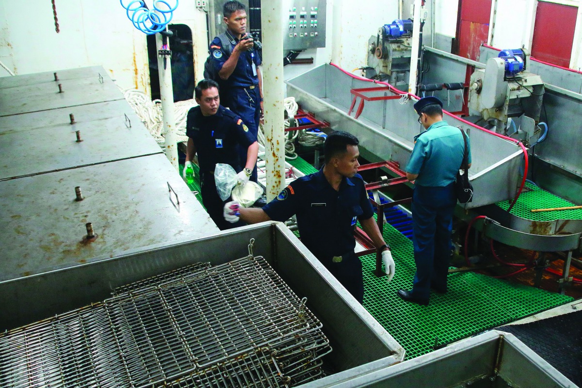 In this photograph taken on July 15, 2019 Indonesian officers check the MV Nika vessel after it was detained by Indonesia's authority in Batam, Kepulauan Riau.  AFP / Sei Ratifa