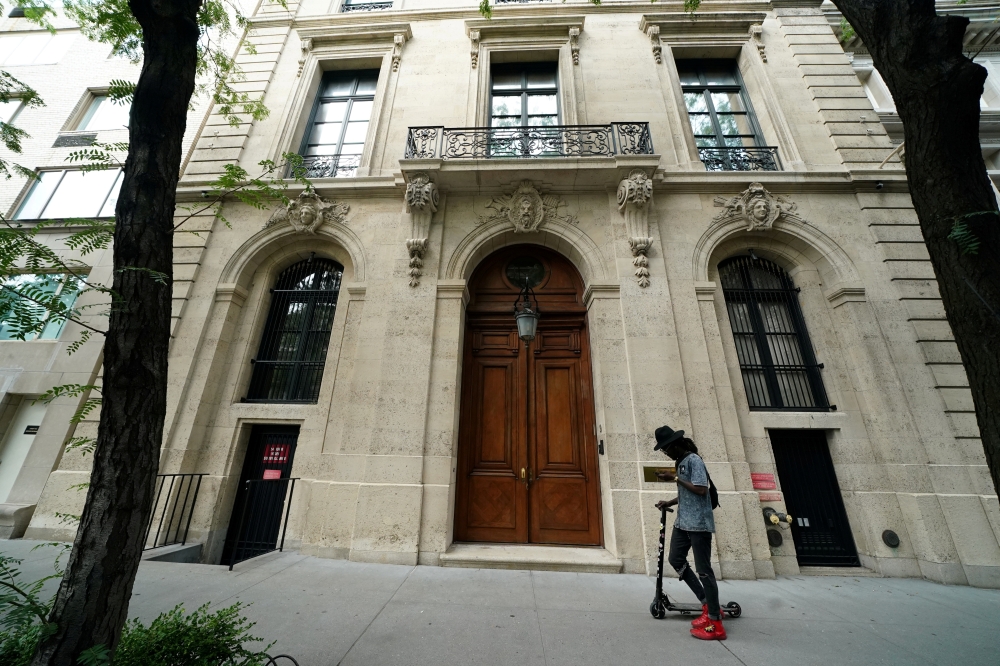A man walks past the front door of the upper east side home of Jeffrey Epstein in New York, US, July 8, 2019. Reuters/Carlo Allegri
