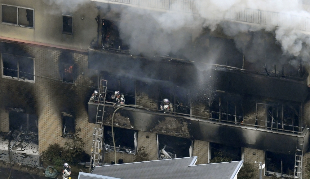 An aerial view shows firefighters battling the fires at the site where a man started a fire after spraying a liquid, at a three-story studio of Kyoto Animation Co. in Kyoto, western Japan, in this photo taken by Kyodo July 18, 2019. Kyodo/via Reuters