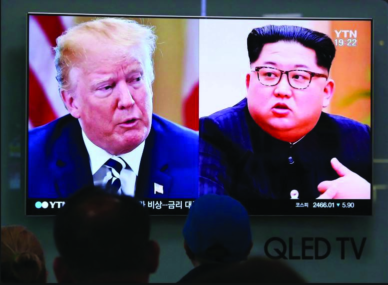 People watch a TV screen showing images of US President Donald Trump and North Korean leader Kim Jong-Un at a railway station in Seoul.