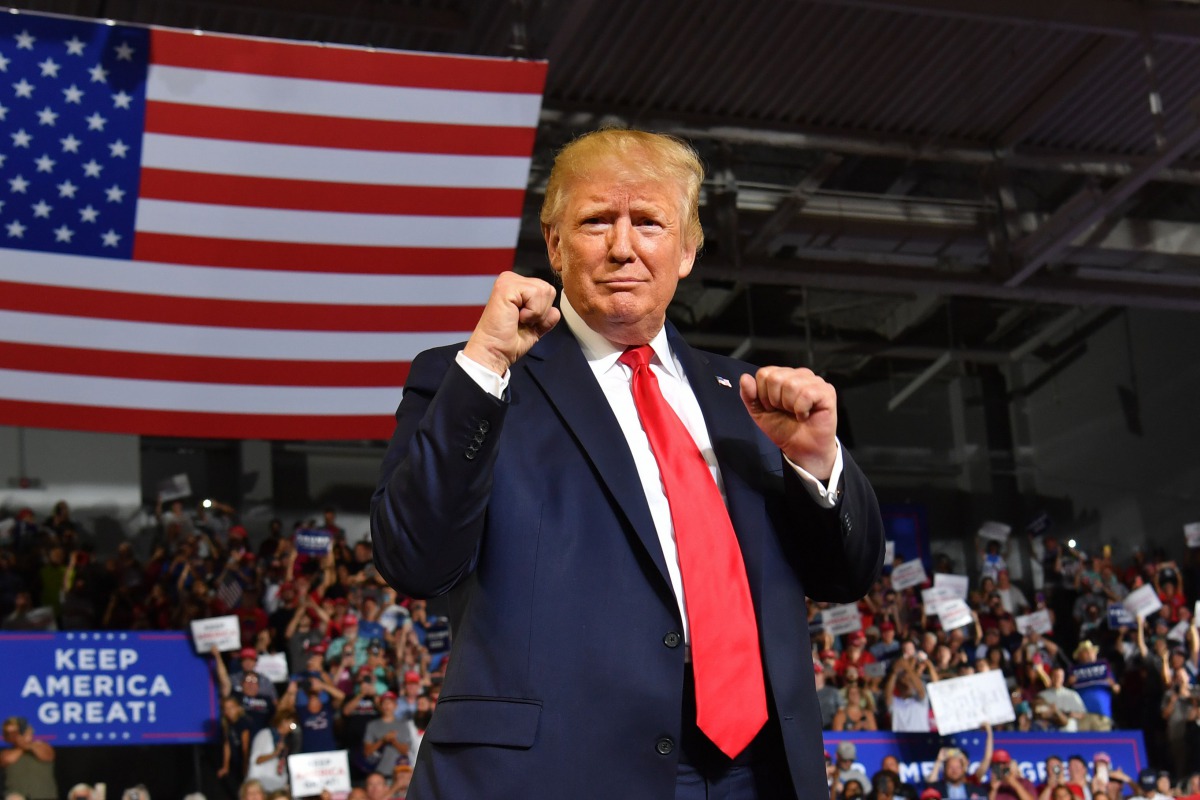  In this file photo taken on July 17, 2019 US President Donald Trump pumps his fists as he arrives for a 