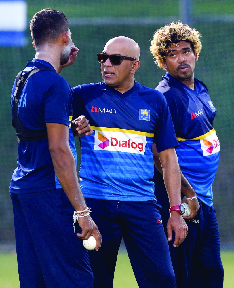 Sri Lankan coach Chandika Hathurusingha (centre) talks with Dasun Shanaka (left) as Lasith Malinga looks on during a training session in Dubai, in this September 14, 2018 file photo.