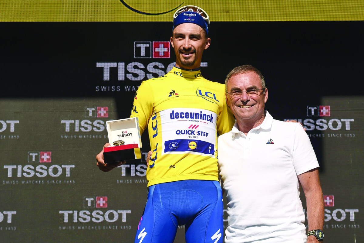 France's Julian Alaphilippe (L) poses with former French champion Bernard Hinault as he celebrates his overall leader's yellow jersey on the podium of the thirteenth stage of the 106th edition of the Tour de France cycling race, a 27,2-kilometer individua