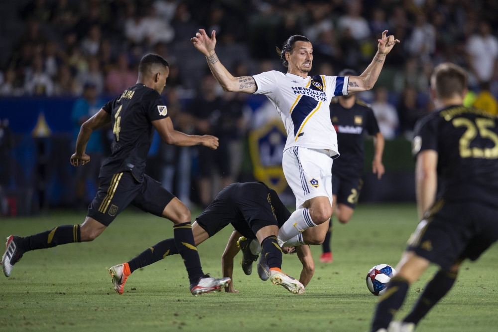  LA Galaxy forward Zlatan Ibrahimovic (9) is tripped up by Los Angeles FC midfielder Eduard Atuesta (20) while battling for the ball during the second half at Dignity Health Sports Park. (Kelvin Kuo-USA TODAY Sports)