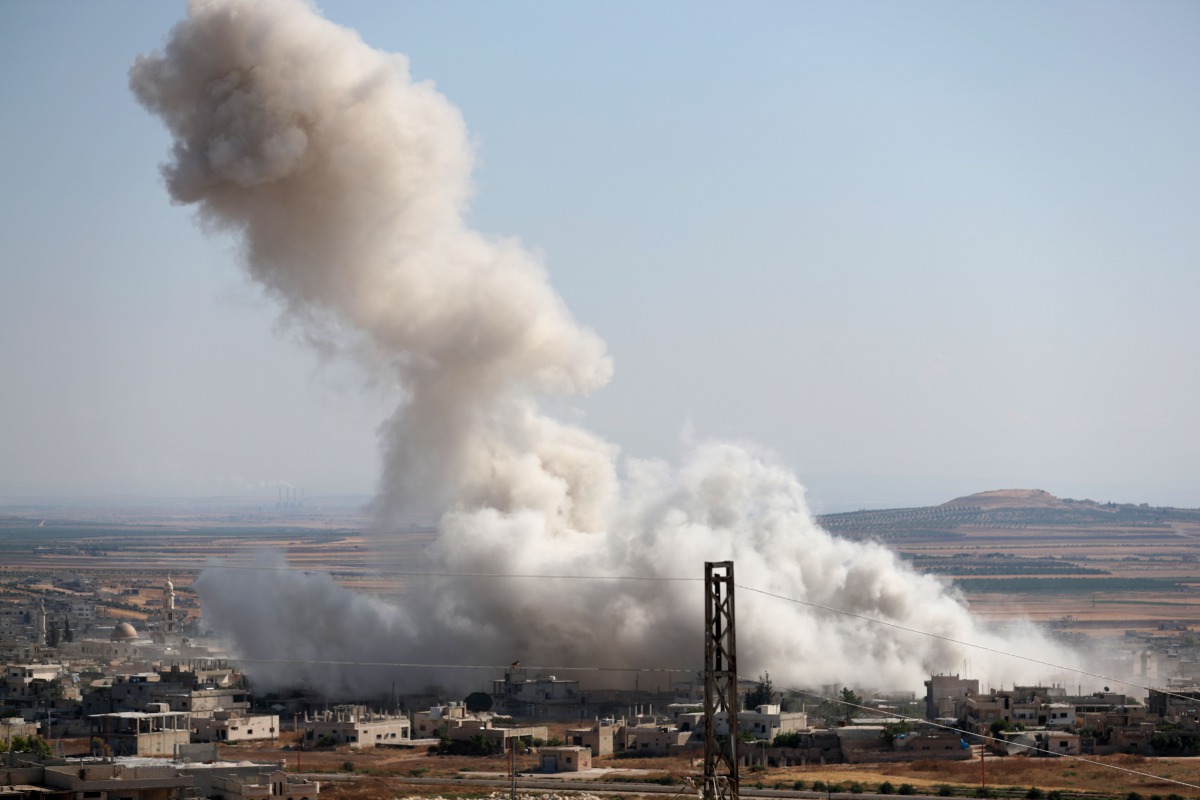 Smoke billows above buildings during a reported air strike by pro-regime forces on Khan Sheikhun in the Syria's Idlib province on July 19, 2019.  AFP / Omar Haj Kadour