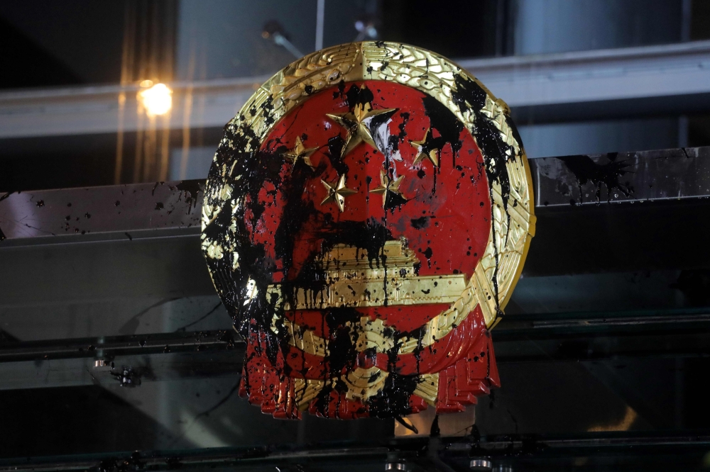 A sign is seen defaced by protesters at the Chinese liaison office after a march against a controversial extradition bill in Hong Kong on July 21, 2019. Masked protesters threw eggs at China's office in Hong Kong on July 21 following another massive rally