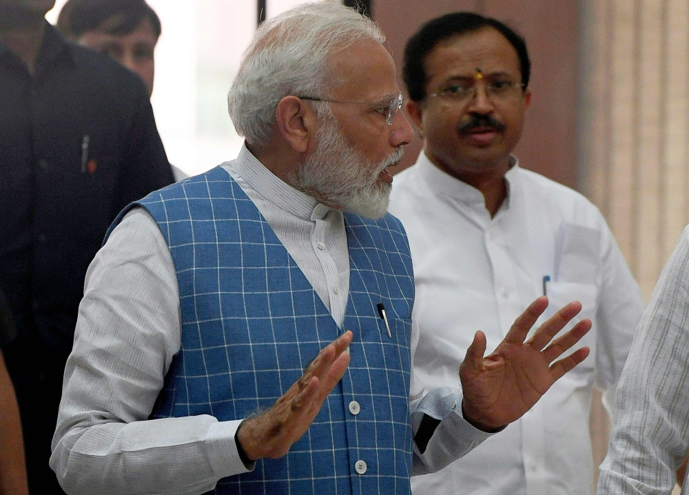 India Prime Minister Narendra Modi gestures while talking with Parliamentary Affairs Minister and Junior Foreign Minister V. Muraleedharan (R) prior to a Bhartiya Janata Party (BJP) Parliamentary Committee meeting at the Parliament house in New Delhi on J