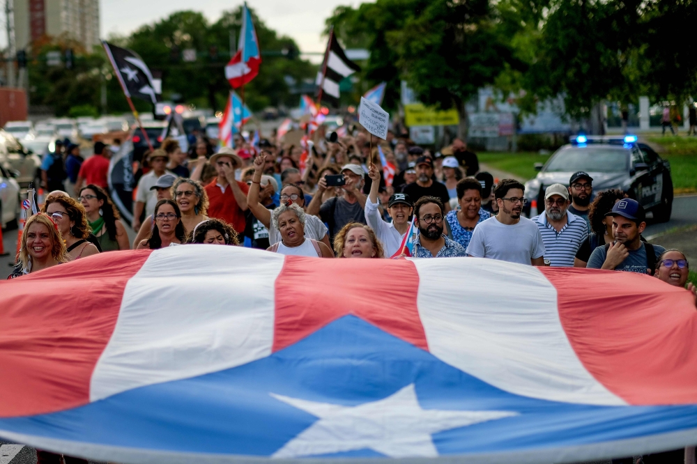 FILE PHOTO: People march in protest in San Juan on against the next in line for Puerto Rico's governor, Wanda Vazquez, Puerto Rico's current Secretary of Justice. AFP / Ricardo ARDUENGO
