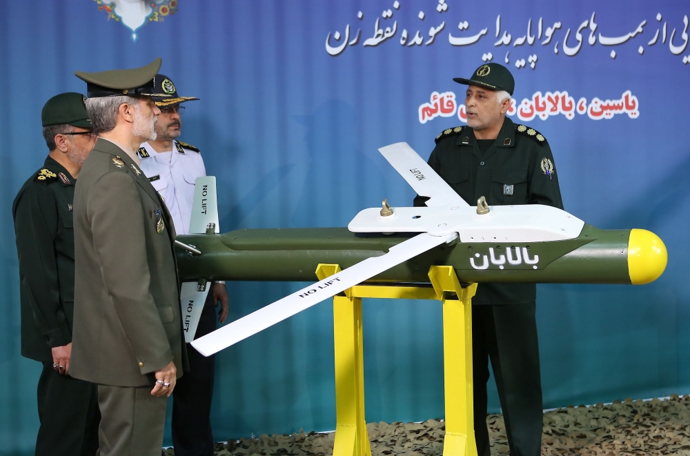 A handout picture released by Iran's Defence Ministry on August 6, 2019 shows Defence Minister Brigadier General Amir Hatami (L, front) standing by the missile 