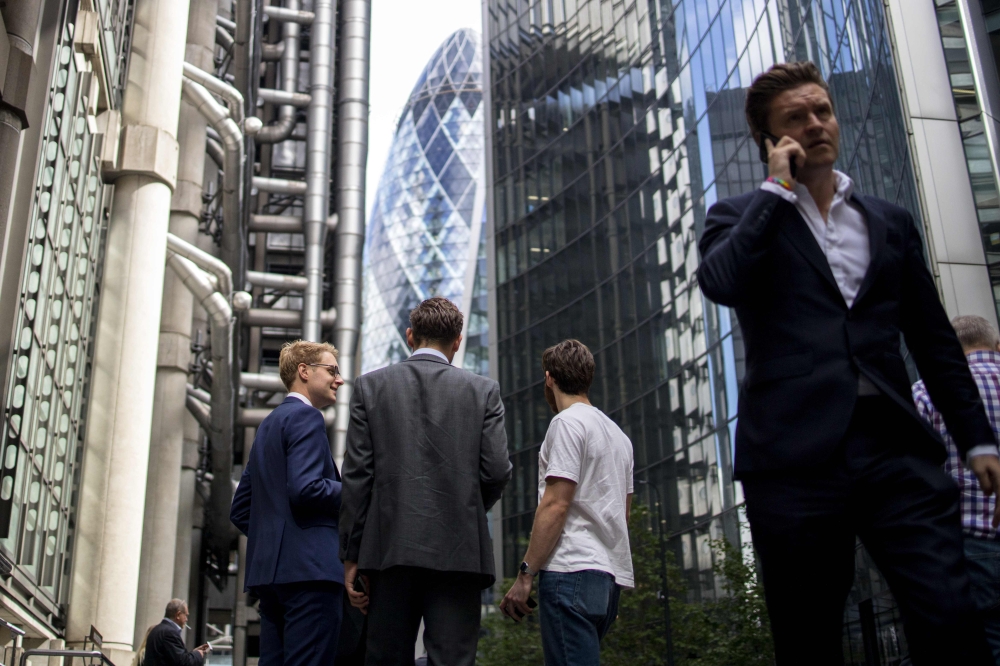 Businessmen speak in the street in the City of London on August 9, 2019. (AFP / Tolga Akmen)