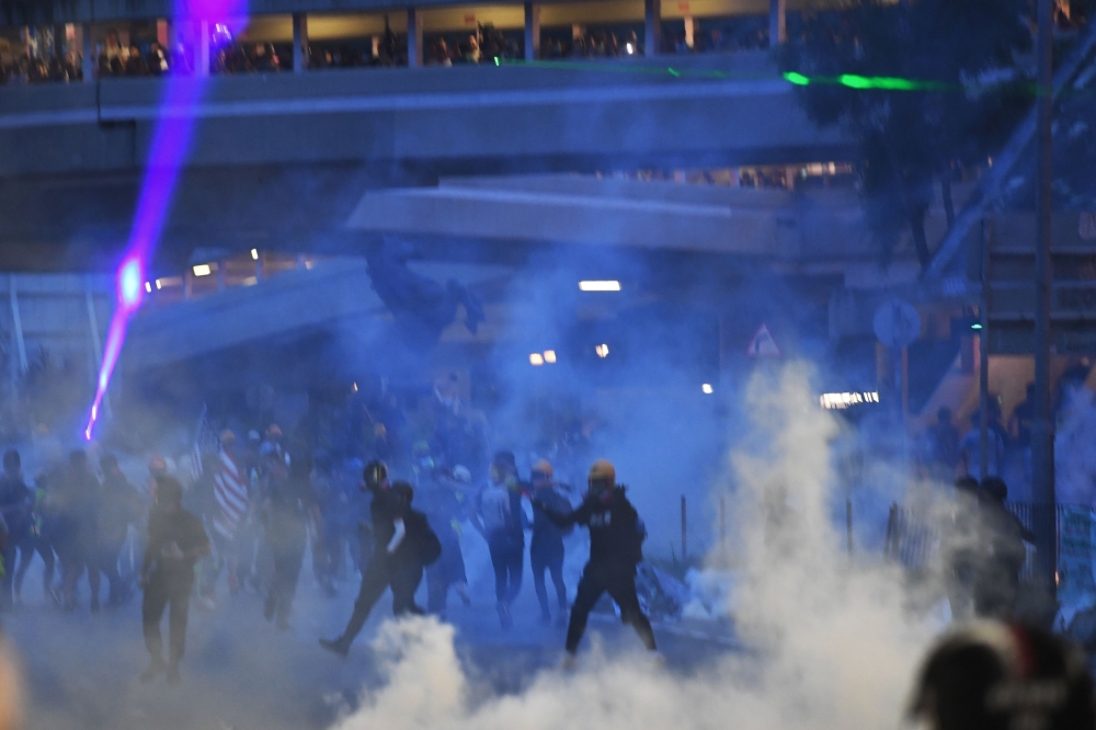 Protesters throw back tear gas cannisters fired by the police in Tai Wai in the New Territories of Hong Kong on August 10, 2019. (AFP / Manan VATSYAYANA)