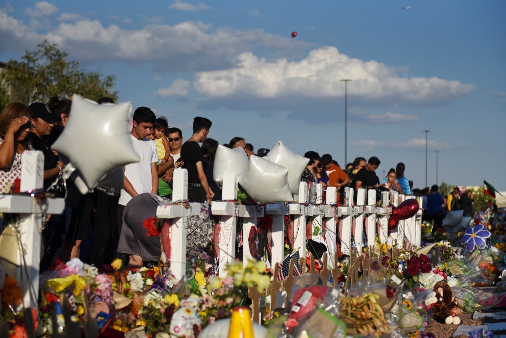 FILE PHOTO: People gather to pay their respects at a growing memorial three days after a mass shooting at a Walmart store in El Paso, Texas, U.S. August 6, 2019. REUTERS/Callaghan O'Hare