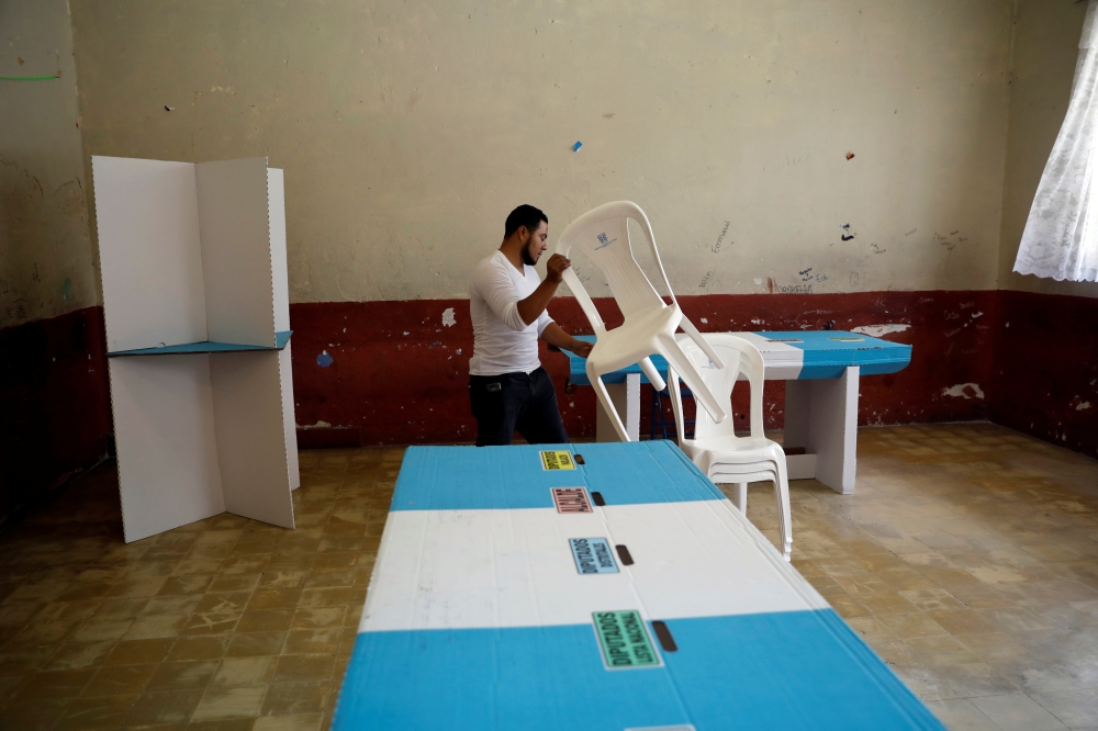 A Staff member of Guatemala's Supreme Electoral Tribunal (TSE) sets up voting equipment ahead of the second round run-off vote, in Guatemala City, Guatemala August 10, 2019. REUTERS/Jose Cabezas