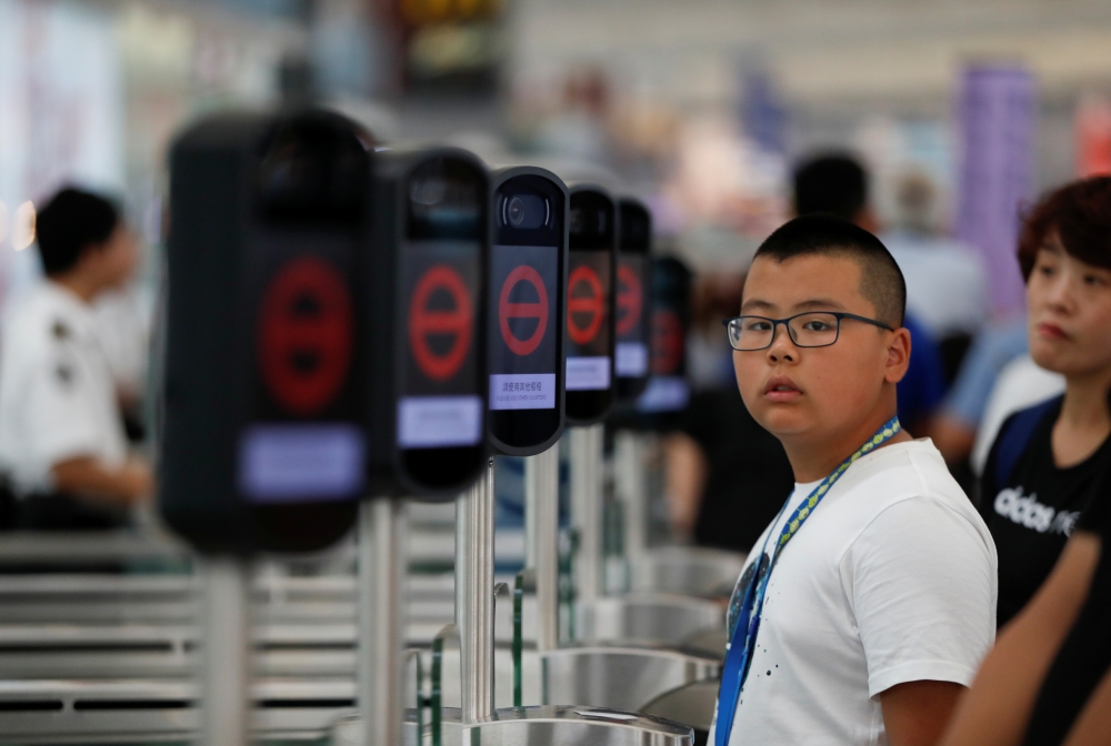 People are seen next to the temporary closed security gates as anti-extradition bill demonstrators protest at the departure hall of Hong Kong Airport, China August 12, 2019. REUTERS/Issei Kato