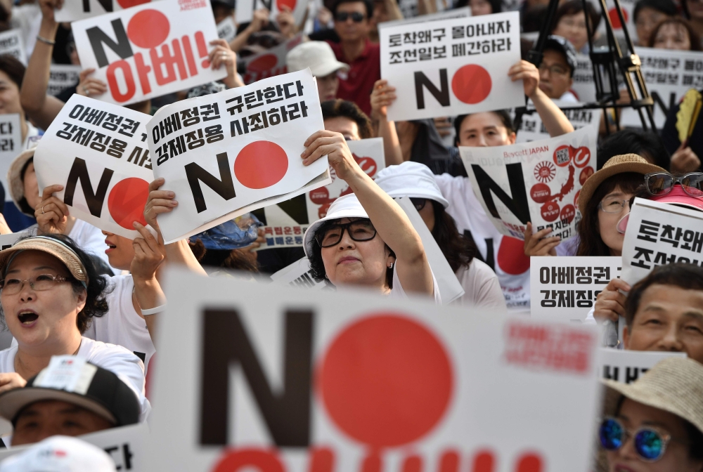 This file photo taken on August 3, 2019 shows protesters holding up placards reading 