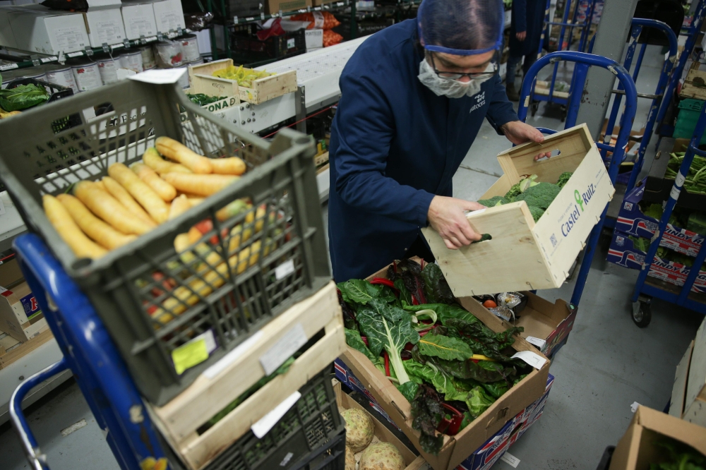 FILE PHOTO: Workers prepare boxes of fresh fruit and vegetables ahead of distribution from the warehouse of Natoora, a fruit and vegetable distribution company, in south London on December 5, 2018.   AFP / Daniel LEAL-OLIVAS 