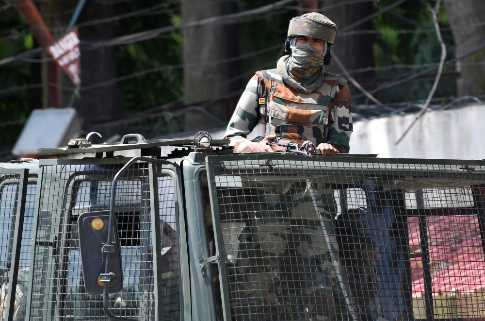(FILES) In this file photo taken on August 18, 2019, an Indian army soldier stands alert in a truck while travelling in a convoy in Srinagar. AFP / Punit Paranjpe 
 