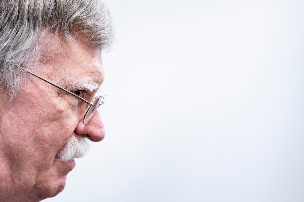 FILE PHOTO: US National Security Advisor John Bolton listens as US President Donald Trump.   AFP / Brendan Smialowski
