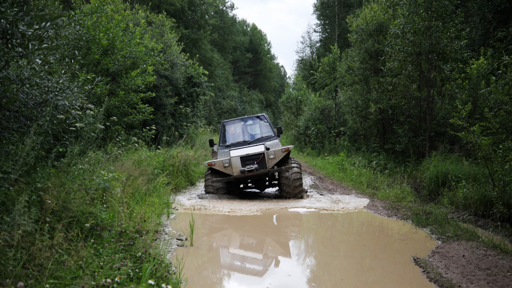 Postwoman Galina Yermolova with her husband drive their homemade off-road vehicle in a forest outside the village of Pikhtovskiy on August 3, 2019. AFP / Alexei Malgavko 