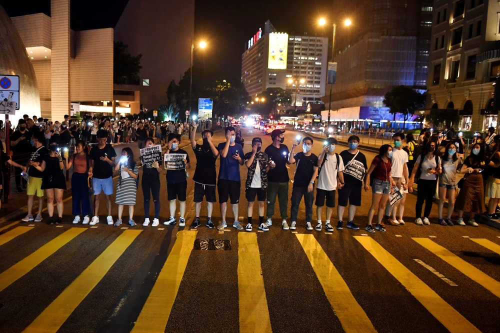 Protesters form a human chain on the street outside the Hong Kong Cultural Centre in Hong Kong on August 23, 2019.