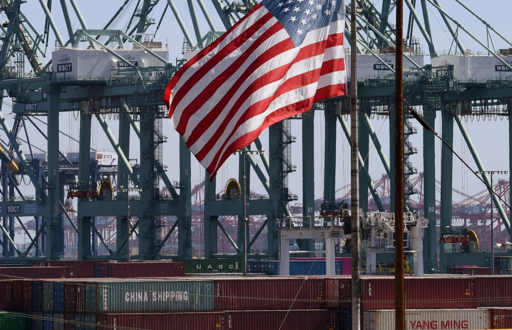 In this file photo taken on September 29, 2018 the US flag flies over Chinese shipping containers that were unloaded at the Port of Long Beach, in Los Angeles County. (AFP / Mark RALSTON)
