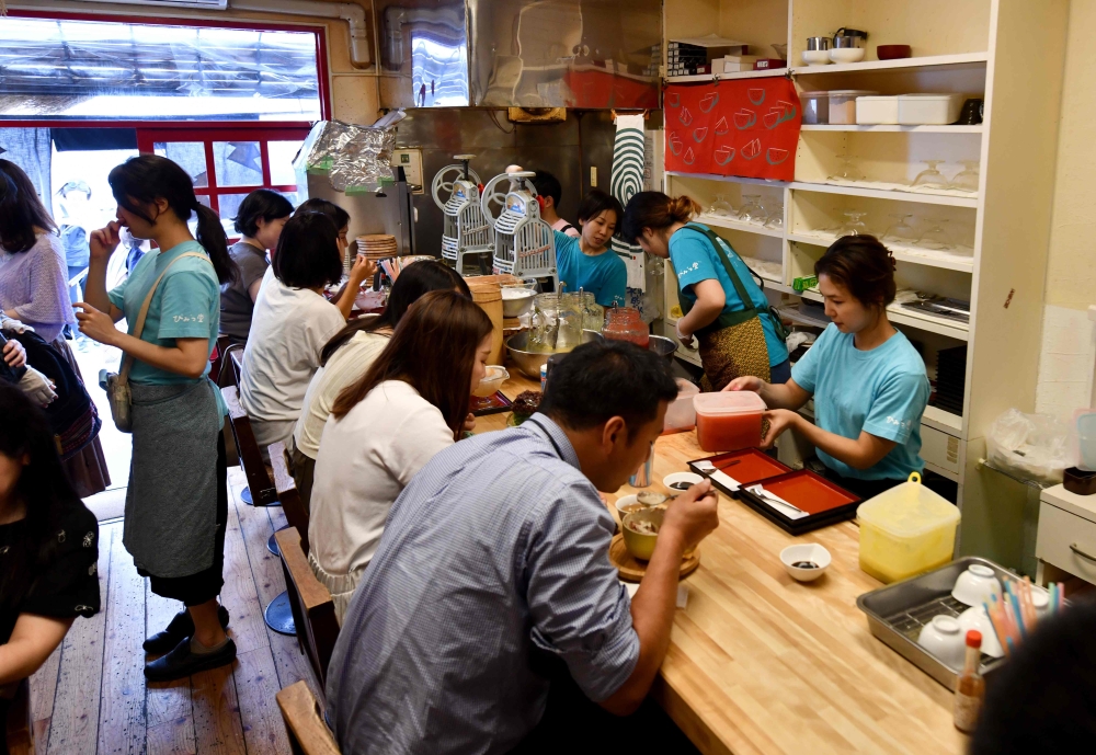 Customers inside a kakigori or shaved ice shop using natural ice in the Yanaka district of Tokyo on June 21, 2019. AFP / Toshifumi Kitamura