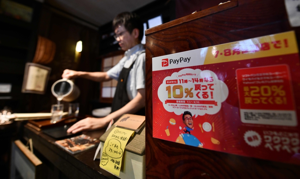 This photo taken on July 25, 2019 shows a notice for payment via PayPay -- a tie-up between Softbank and Yahoo -- displayed at a Koguma restaurant in Tokyo. AFP / Toshifumi Kitamura 