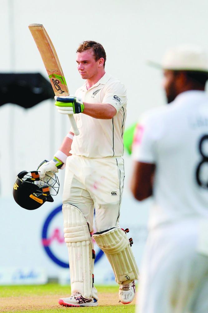New Zealand's cricketer Tom Latham (L) raises his bat after he scored a century (100 runs) during the third day of the final cricket Test match between Sri Lanka and New Zealand at P. Sara Oval cricket stadium in Colombo on August 24, 2019. AFP / Lakruwan