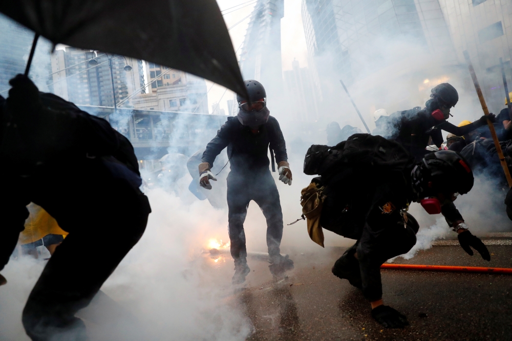Demonstrators are surrounded by tear gas during a protest in Tsuen Wan, in Hong Kong, China, August 25, 2019. REUTERS/Kai Pfaffenbach
