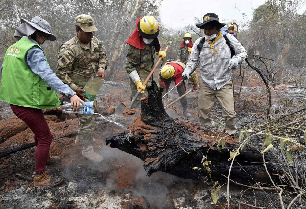 Soldiers, firemen and volunteers combat forest fires in the surroundings of Robore in eastern Bolivia, on August 25, 2019.  AFP / Aizar Raldes
 