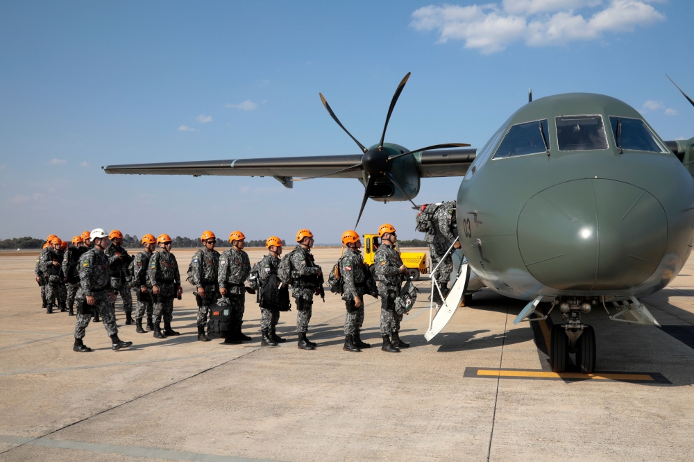 National Force military firefighters stand in line to board a plane to Rondonia northern Brazil, to help fight fires in the Amazon rainforest at the Military Air Base in Brasilia, on August 24, 2019.   AFP / Sérgio Lima