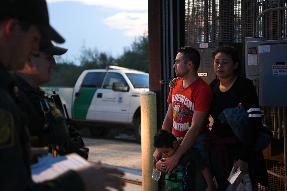 Honduran migrants Diego and Nely stand with three year-old son Diego Jr. after turning themselves in to U.S. Border Patrol agents to seek asylum following an illegal crossing of the Rio Grande in Hidalgo, Texas, U.S., August 23, 2019. REUTERS/Loren Elliot