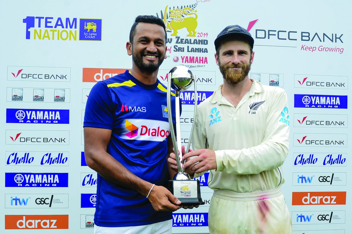 Sri Lanka's cricket team captain Dimuth Karunaratne (L) and New Zealand's cricket team captain Kane Williamson hold the trophy during the presentation ceremony on the final day of the final cricket Test match between Sri Lanka and New Zealand at P. Sara O