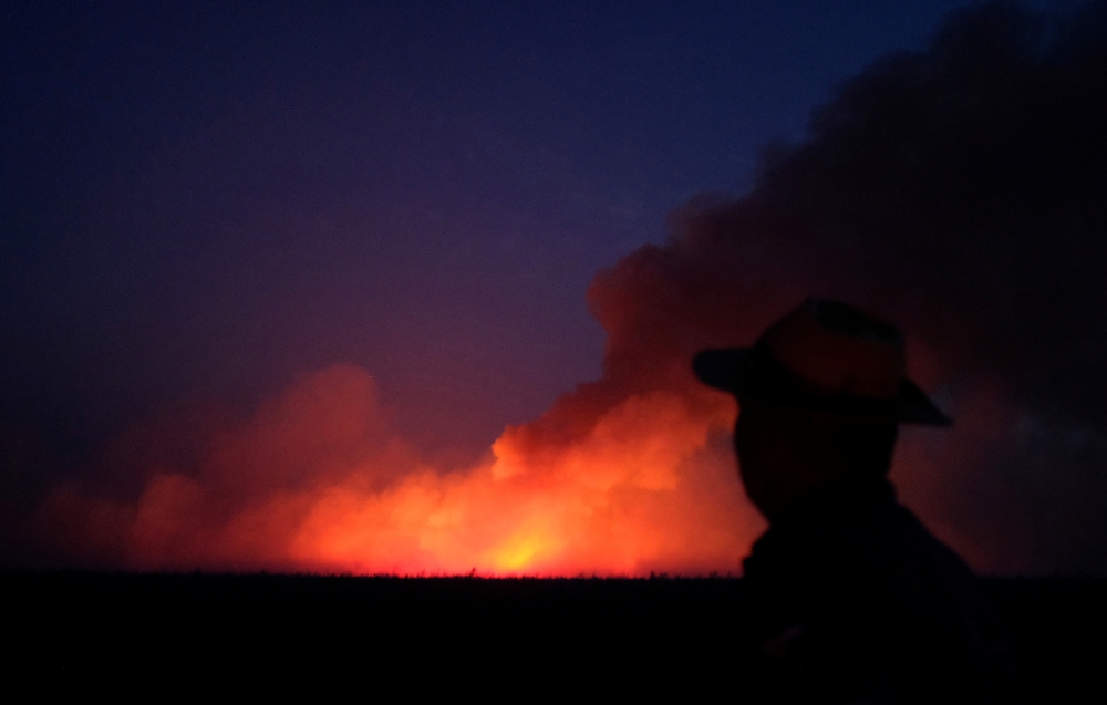 A man is seen on a burning tract of the Amazon jungle in Canarana, Mato Grosso state, Brazil August 26, 2019. REUTERS/Lucas Landau 