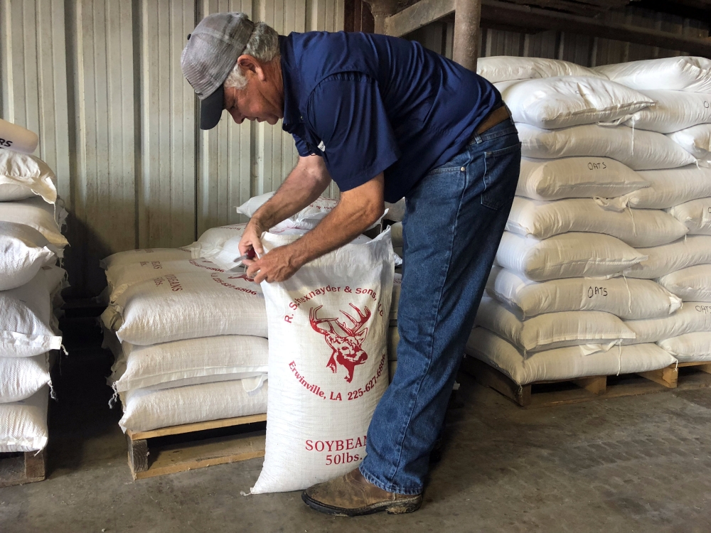 Soybean farmer Raymond Schexnayder Jr closes a bag of soybeans from his farm outside Baton Rouge in Erwinville, Louisiana, July 9, 2018. Reuters/Aleksandra Michalska