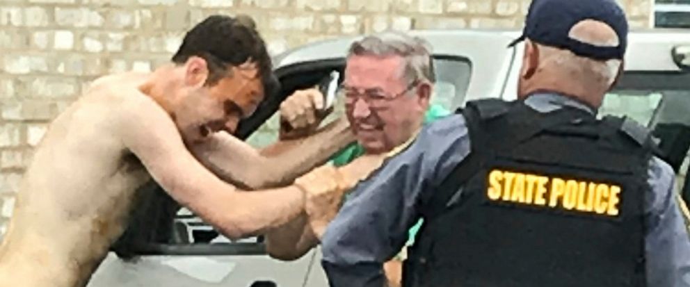 Matthew Thomas Bernard puts his hands on Keeling Baptist Church groundskeeper Loyd Gauldin, as a state police officer attempts to take him into custody on Tuesday, Aug. 27, 2019 in Keeling, Va. (Image courtesy: Caleb Ayers/via heraldmailmedia.com)