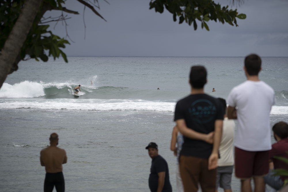 People gather at the coast hours before the storm enters in Patillas, Puerto Rico on, August 28, 2019. AFP / Eric Rojas