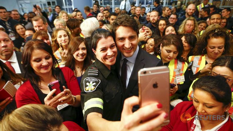 Canada's Prime Minister Justin Trudeau poses with airport staff as they await Syrian refugees to arrive at the Toronto Pearson International Airport in Mississauga, Ontario, December 10, 2015. Reuters/Mark Blinch