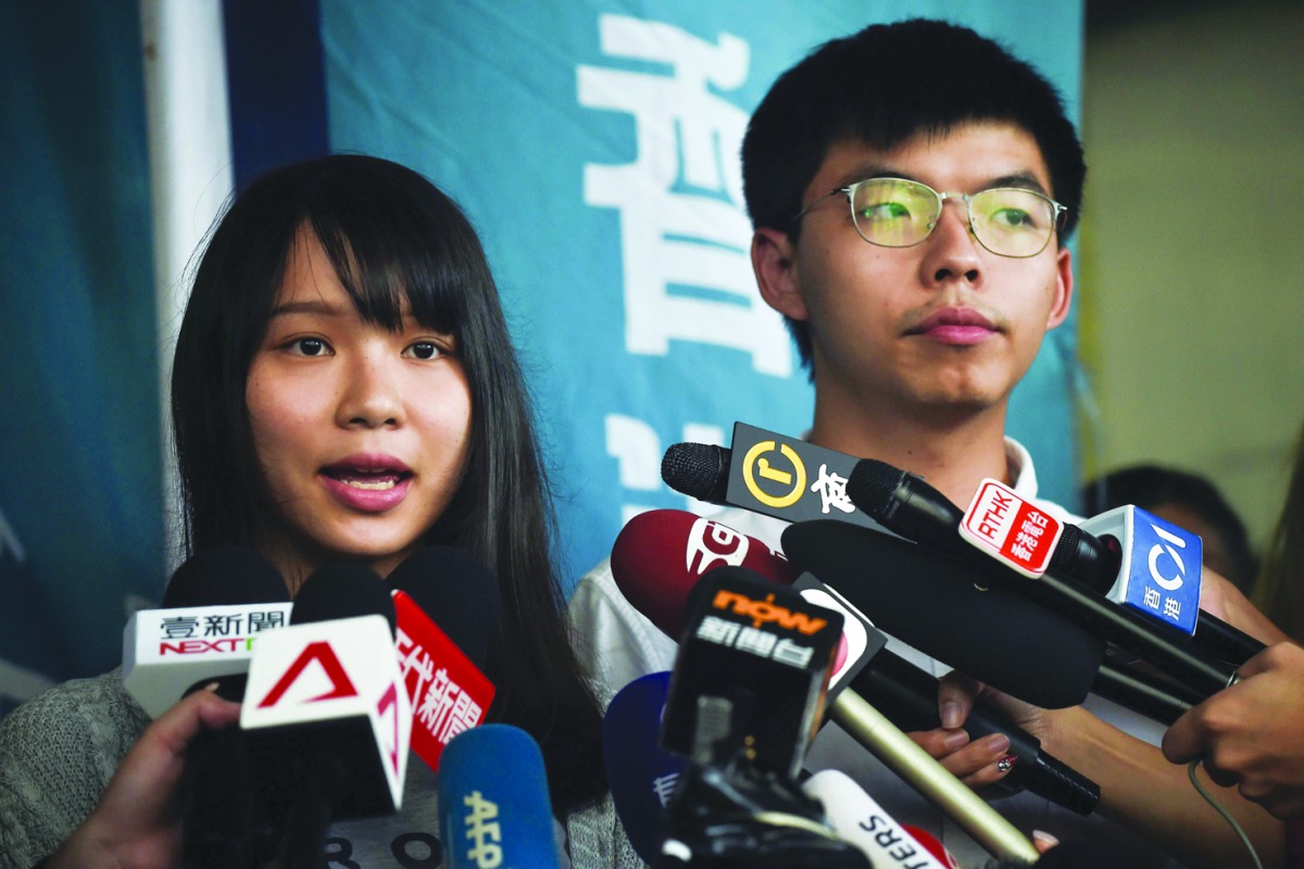 Pro-democracy activists Agnes Chow (L) and Joshua Wong (R) speak to the press after they were released on bail at the Eastern Magistrates’ Courts in Hong Kong on August 30, 2019. AFP / Lillian Suwanrumpha
