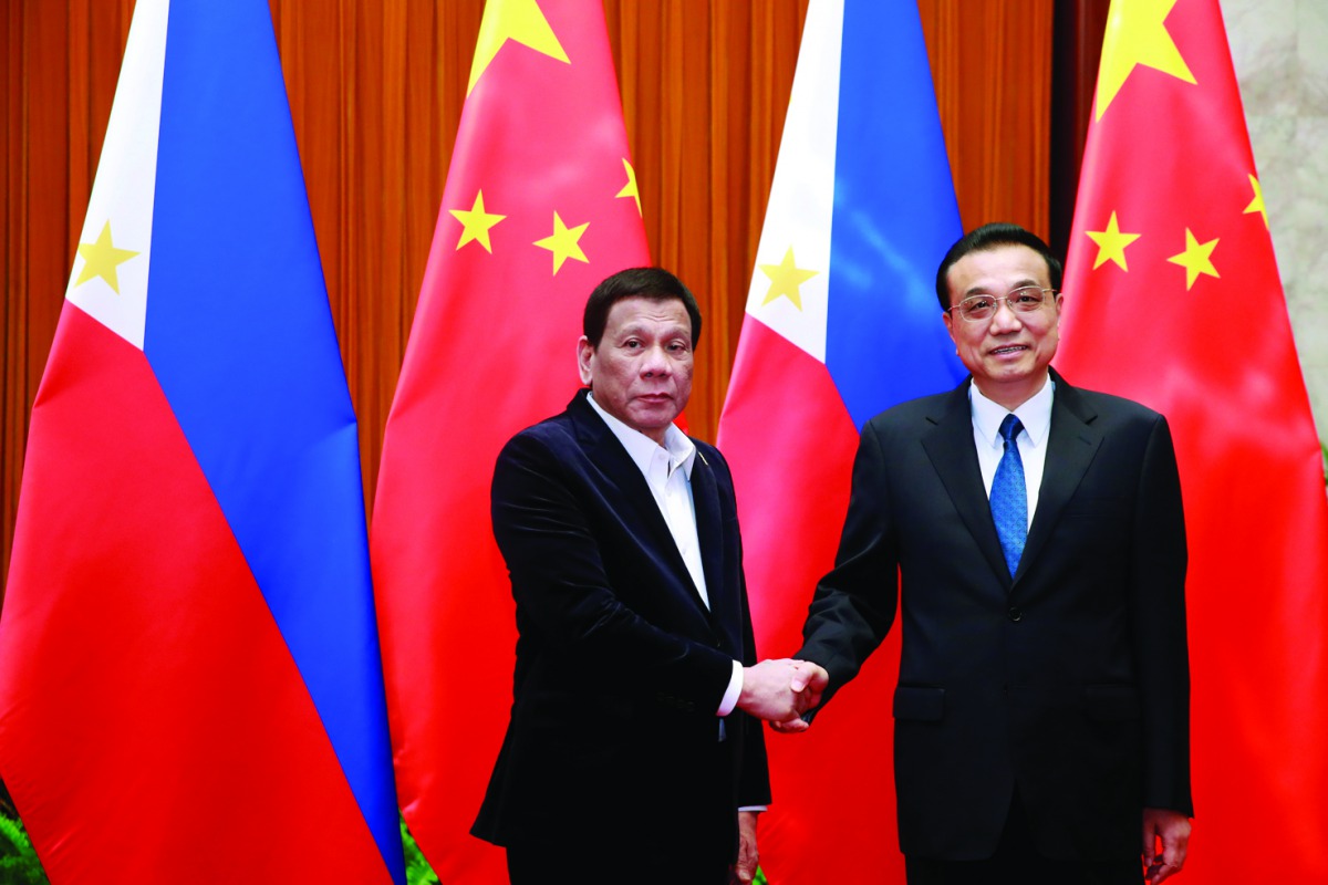 Philippine President Rodrigo Duterte (L) and Chinese Premier Li Keqiang shake hands during their meeting at the Great Hall of the People in Beijing, China, August 30, 2019. How Hwee Young/Pool via Reuters